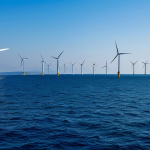 Offshore Wind Farm - Aegean Coast**

"A wide shot of an offshore wind farm off the coast of İzmir, Turkey. Modern wind turbines stand tall against a clear blue sky and calm Aegean Sea. Several fishing boats are visible in the distance, showcasing the coexistence of energy production and traditional livelihoods. Fully clothed fishermen are working. The image should convey clean energy, sustainability, and Turkish ingenuity. safe for work, appropriate content, fully clothed, professional, perfect anatomy, natural proportions, high quality, daytime lighting, realistic."

**